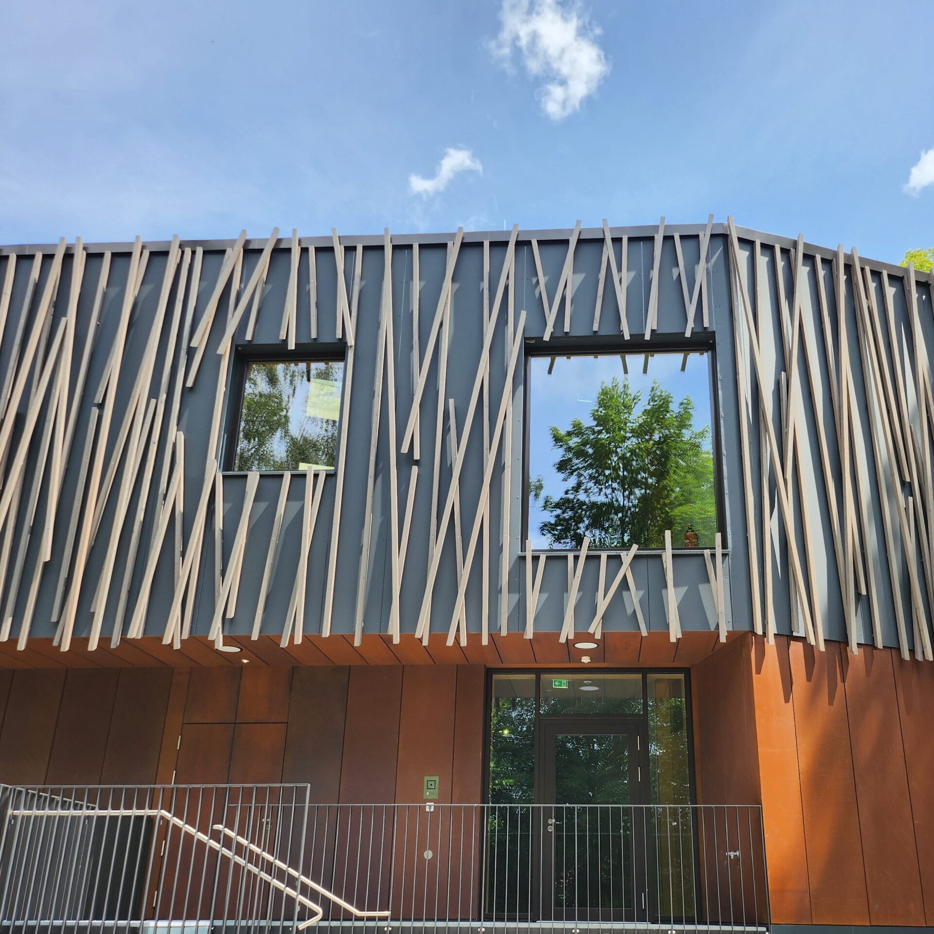 Neubau Realschule Oberelkofen, hinterlüftete Aluminium Verbundmaterial Fassade, Alucobond, überdeckt mit Lärcheholzlatten in Mikadowurfform